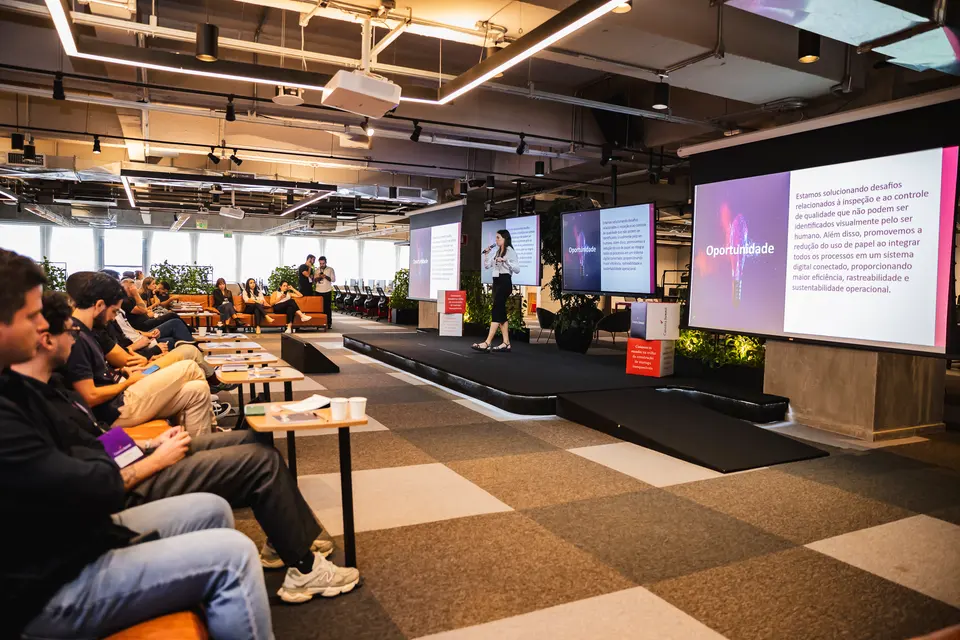 Wide view of an auditorium during a session, slides on large screens
