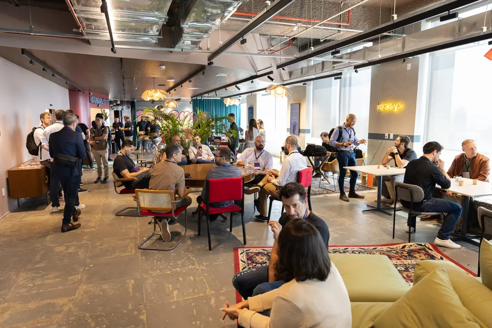 Participants networking around tables in a lounge