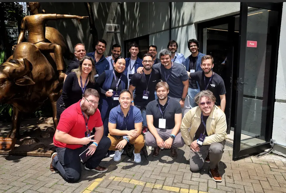 Cohort group photo outside the venue, next to a bronze bull statue