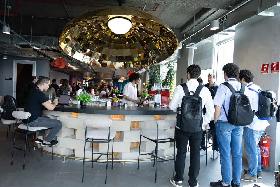 Participants with backpacks gathered by a bar counter